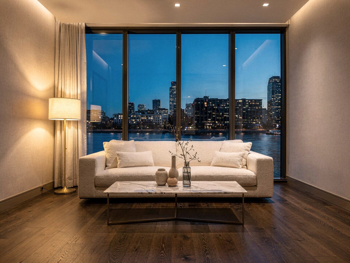 Living room with floor-to-ceiling windows and a river view at dusk