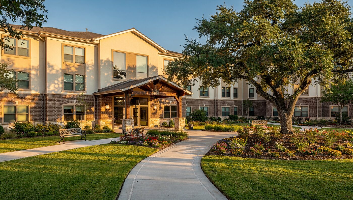 Oakhaven Senior Living, a two-story brick and stucco community with a covered entry and garden courtyard