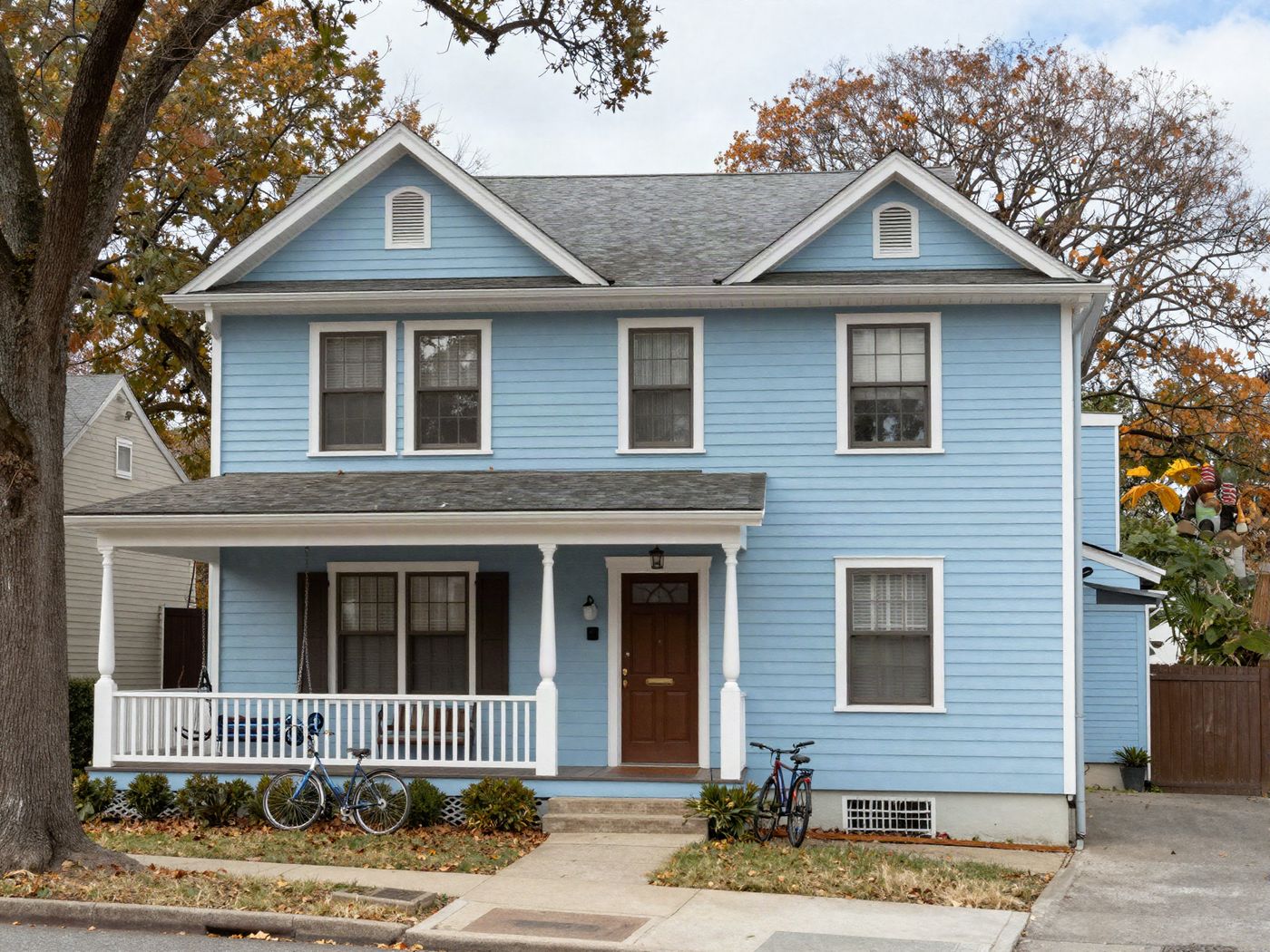 Varsity House, a two-story blue house with a covered front porch, seen from Varsity Avenue